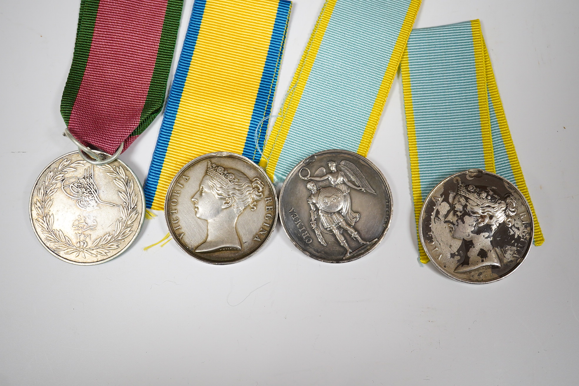 Two Crimea medals, a Baltic medal, all disc only and unnamed with a replica Turkish Crimea medal, unnamed, (3).